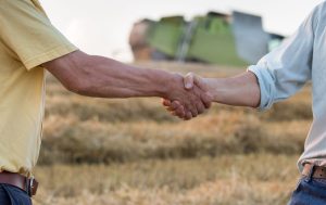 Two farmers shaking hands in field - Agribusiness Recruiting - Agricultural Appointments