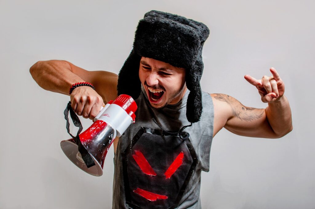 Man shouting into megaphone wearing furry hat