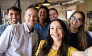 Smiling team of diverse professionals taking a group selfie