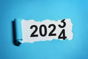 Year 2024 revealed under torn blue paper